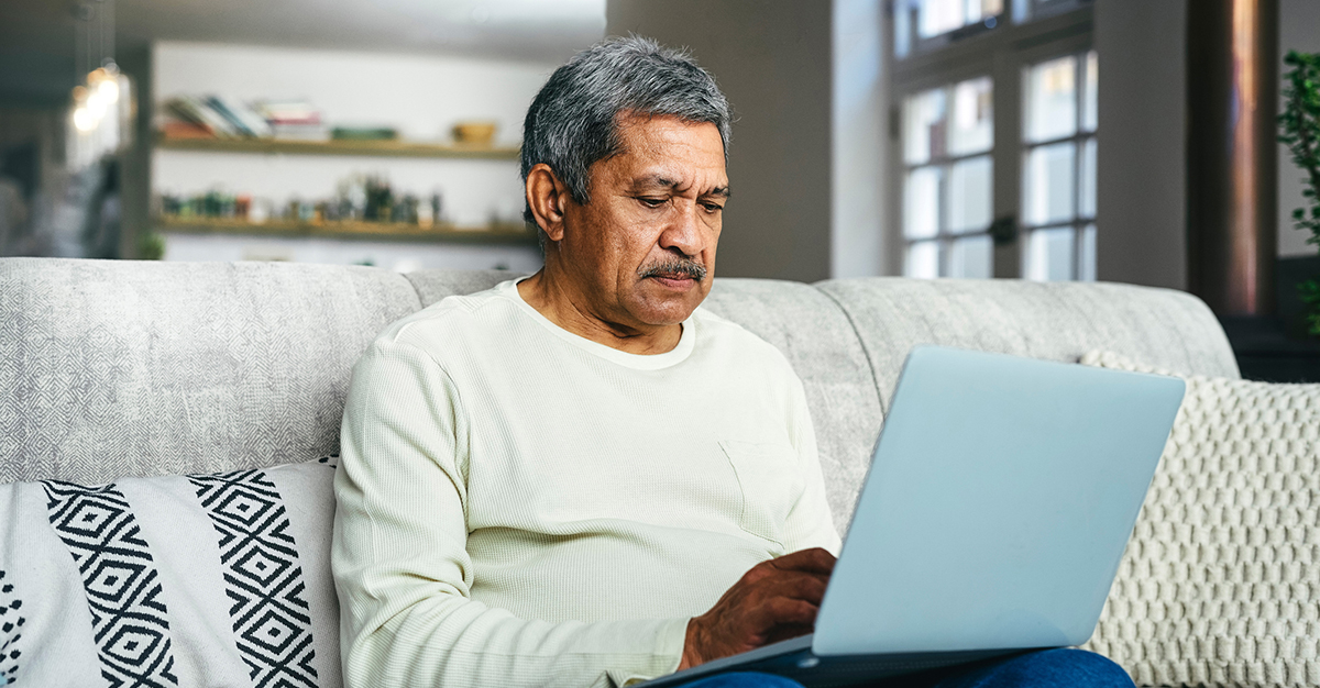 An elderly man using a laptop.