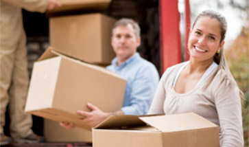 smiling couple loading boxes onto truck